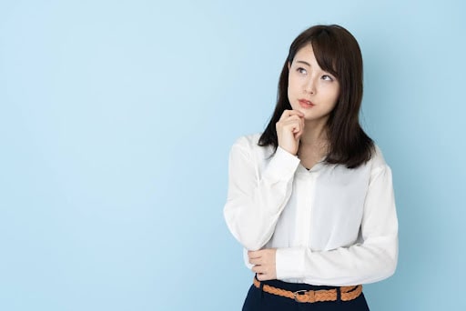 顎に手を当て疑問をいだいている女性