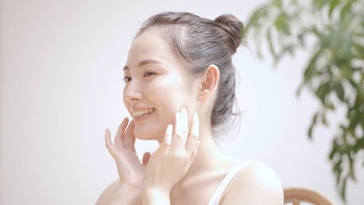 頬に手を当て笑顔の女性