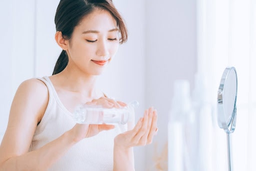 化粧水を手に出す女性