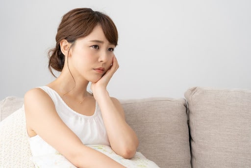 頬杖をついて悩む女性