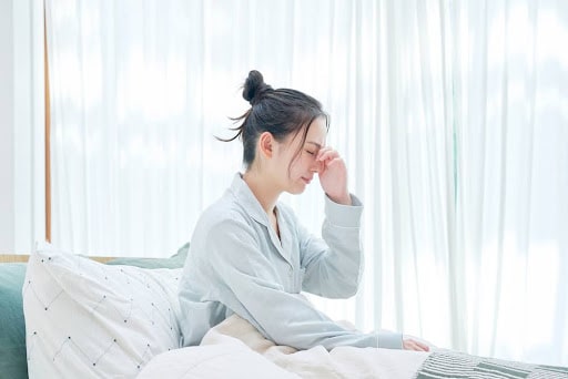 眠そうに目を擦る女性