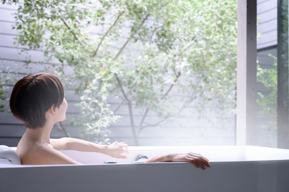 お風呂に入り外を眺める女性