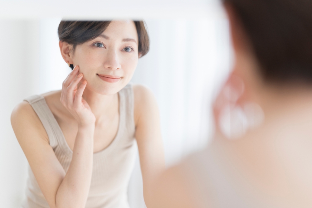 鏡を見て微笑む女性
