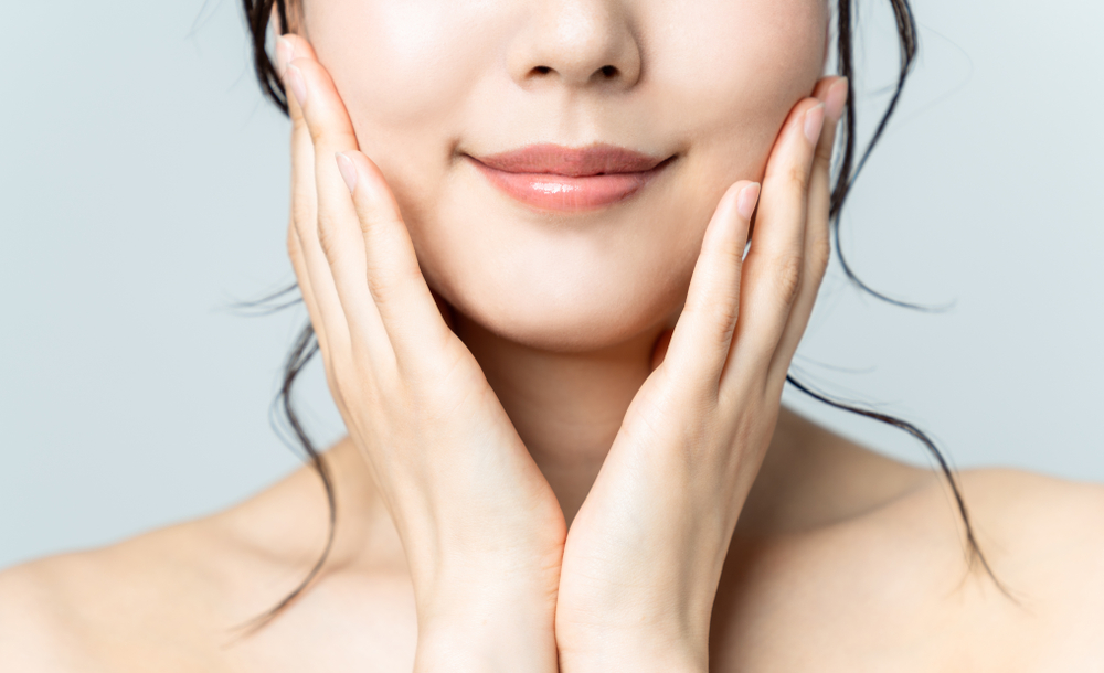 頬を抑えて微笑む女性