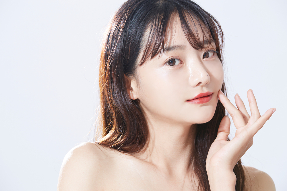 指で頬を触る女性